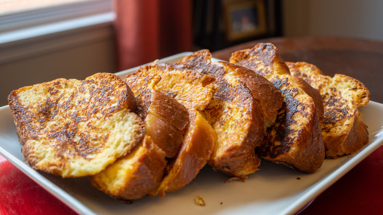 Slices of challah bread french toast on serving plate