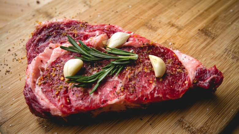 Raw ribeye steak with seasoning