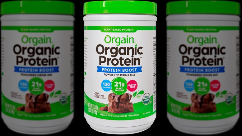 A canister of Orgain organic protein powder on a black background