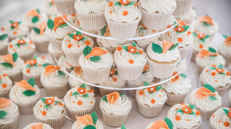 cupcakes arranged on a tiered acrylic serving tray