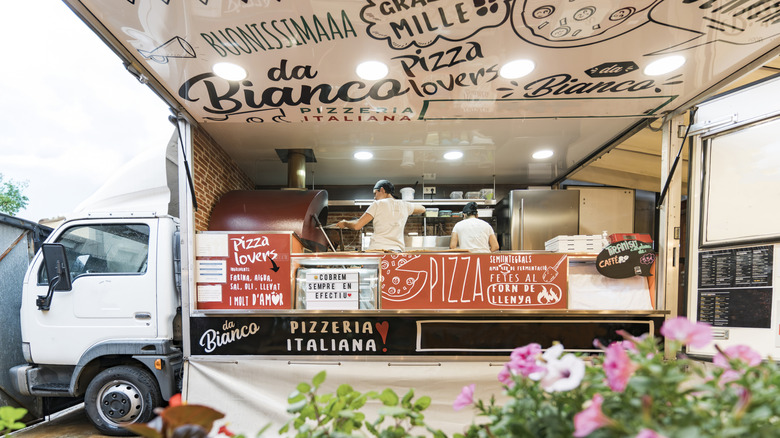 pizza truck with large awning and flowers