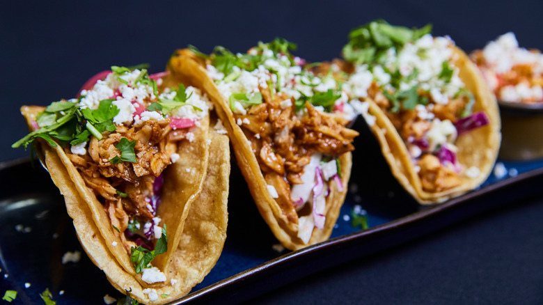 tacos on tray on dark blue background