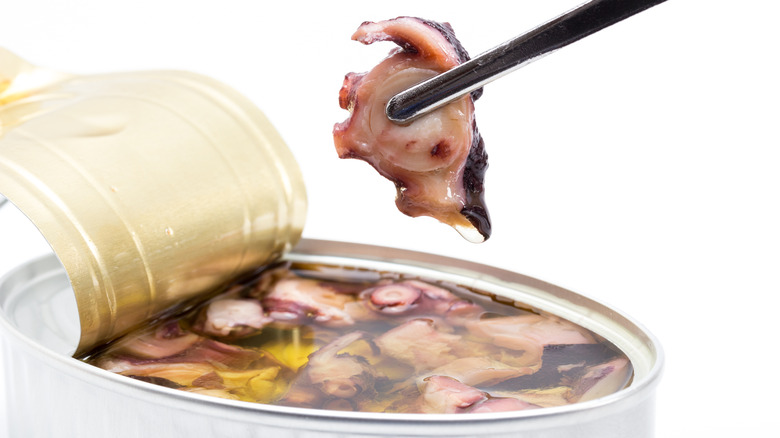 Chopsticks holding canned octopus