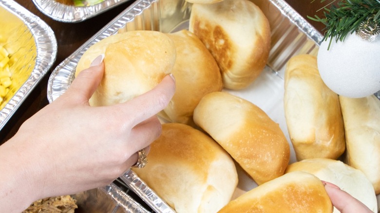 Hands grabbing rolls from table