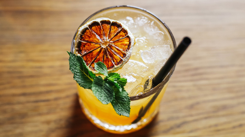 Cocktail with dehydrated orange slice and a mint sprig