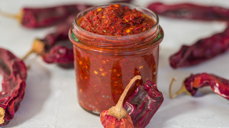 A jar of harissa paste with dried chile peppers