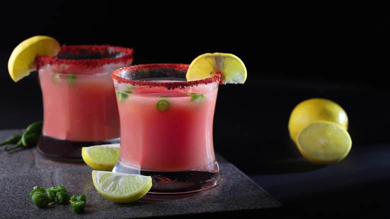 Two guava margarita cocktails garnished with sliced chiles and lime