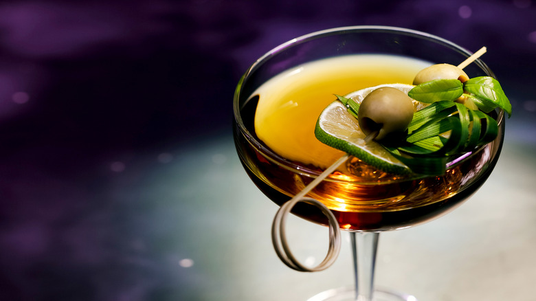 A cocktail with olive juice in a coupe glass