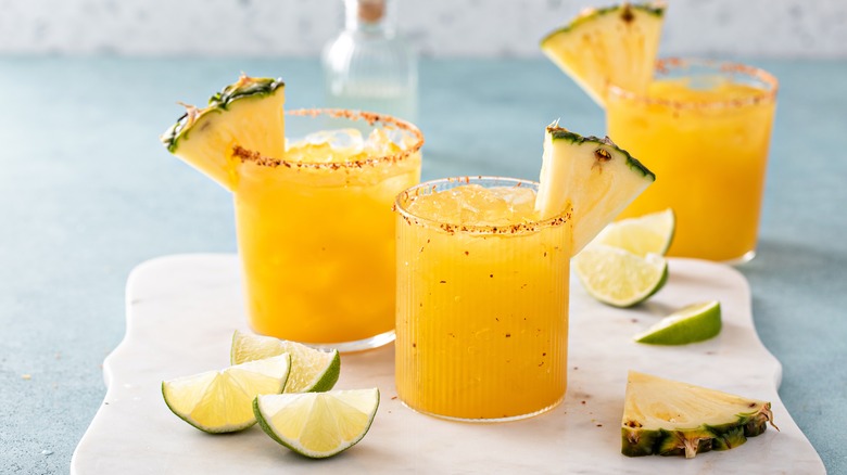 Pineapple margarita cocktails in a cutting board