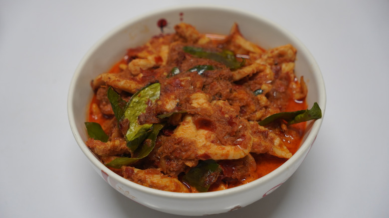 A white bowl with Thai red curry