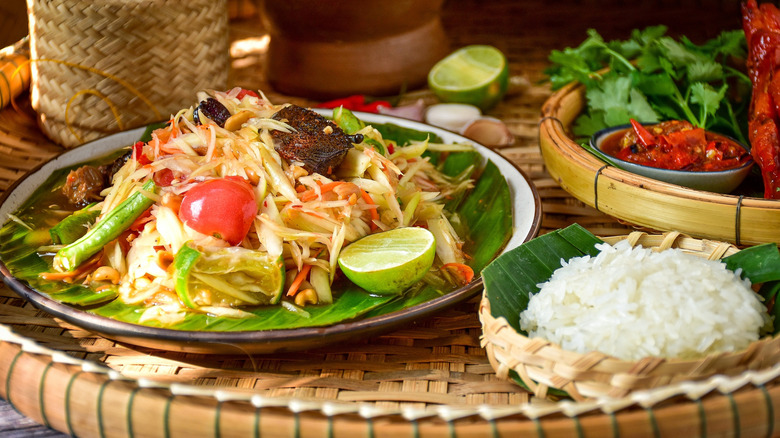 Thai papaya salad with sticky rice on two plates
