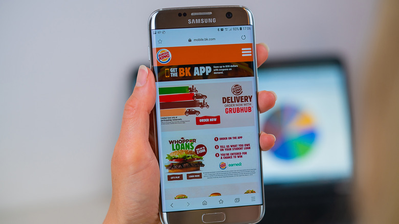 Person holding phone with Burger King app open