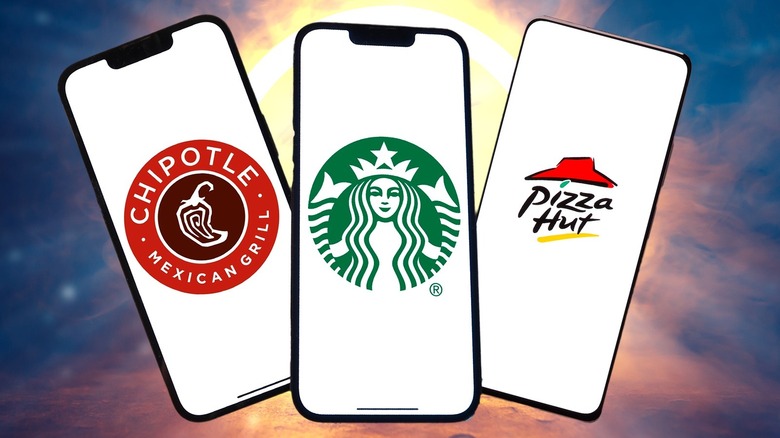 Fast food apps on 3 smart phones against a sky background