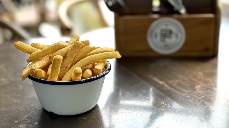 french fries in tin bowl on restaurant table