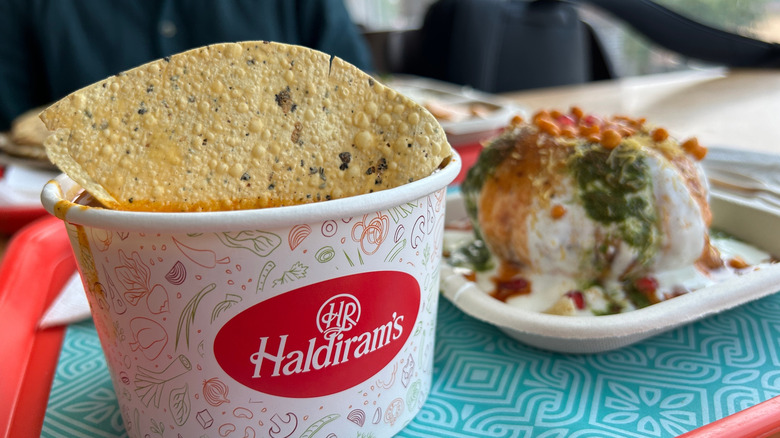 Two dishes from Haldiram's on a red tray with a blue patterned liner