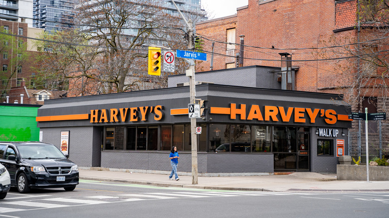 Harvey's storefront in Toronto with orange logo on two sides of a dark gray building