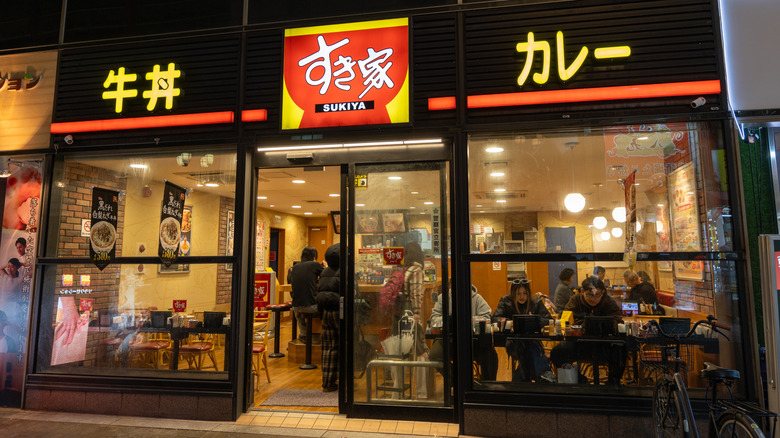 Sukiya storefront in Osaka, taken at night, showing customers inside