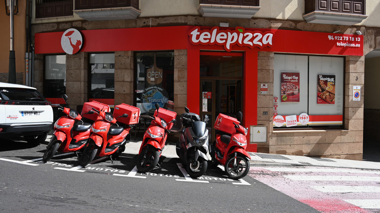 Telepizza storefront in the Canary Islands with delivery motorcycles out front