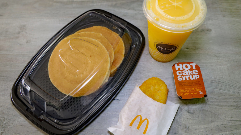 McDonalds Hotcakes with orange juice, a hash brown, and syrup