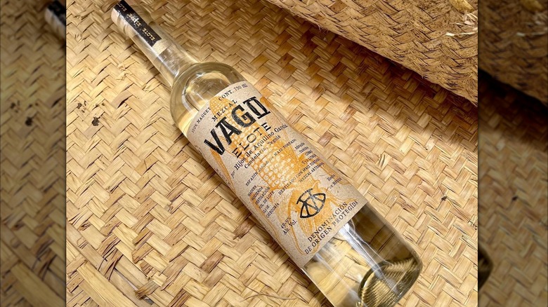 A bottle of Vago Elote mezcal on a woven mat