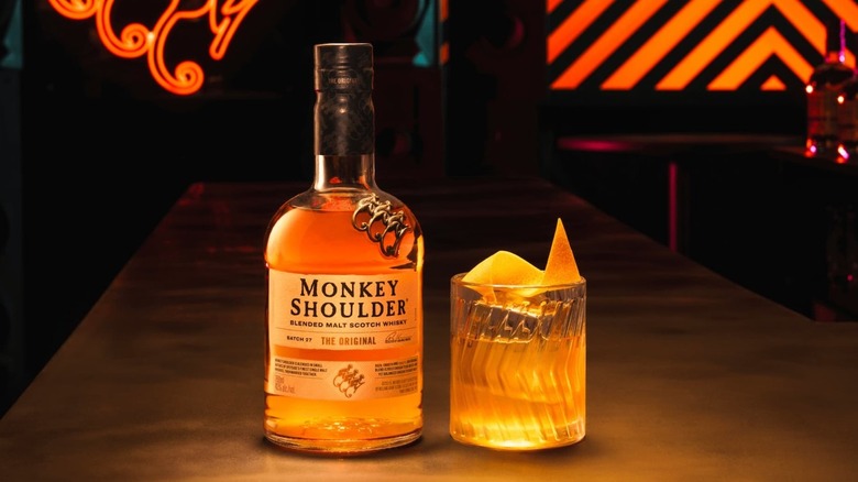 A bottle of Monkey Shoulder Blended Malt Scotch Whisky next to am old fashioned cocktail