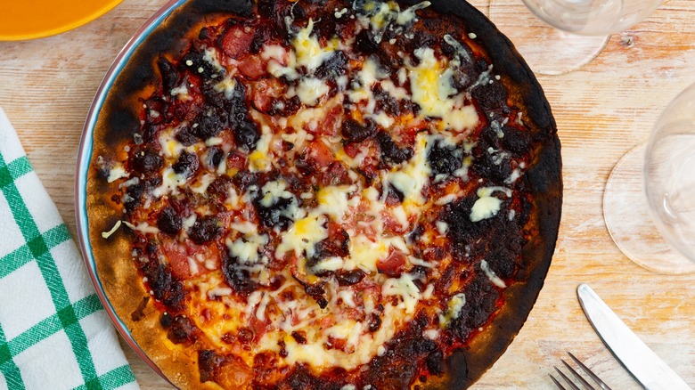 burnt pizza on a plate on a table
