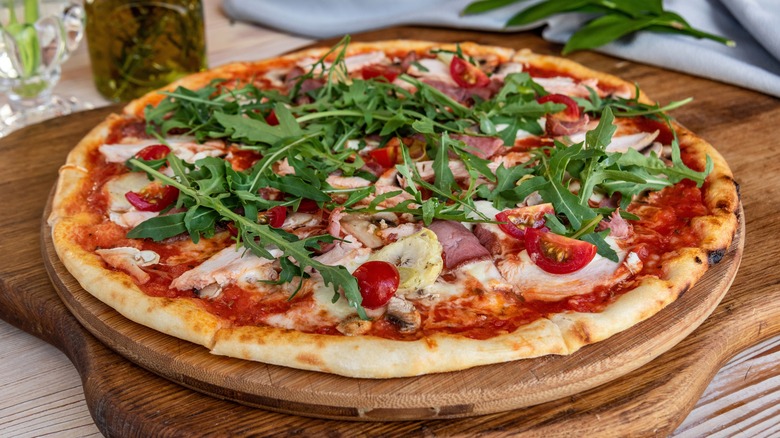finished pizza topped with fresh arugula