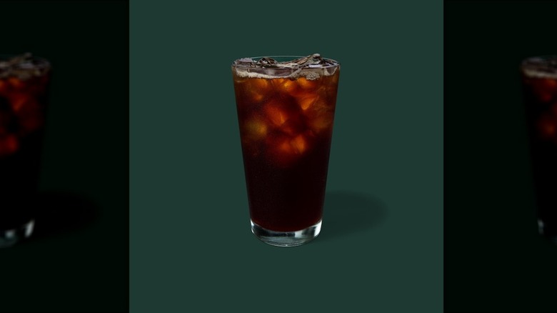 Iced coffee in glass on a green background