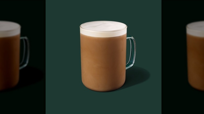 Hot Caffè Misto in a glass mug on a green background