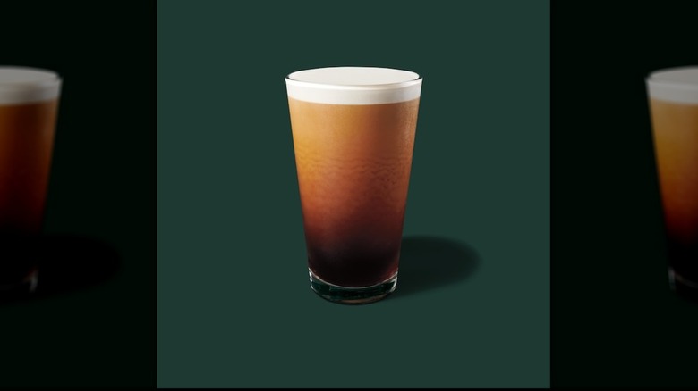 Nitro Cold Brew in a glass cup on a green background