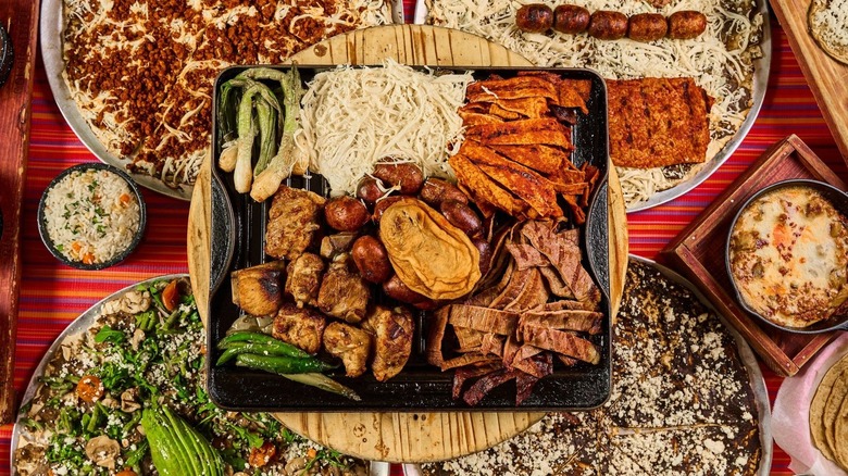 A selection of tlayudas and meats on a large table