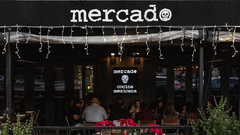 The exterior of a Mercado with a black awning displaying the name
