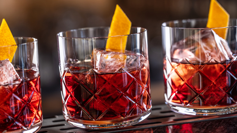 Three Negroni cocktails garnished with orange peel
