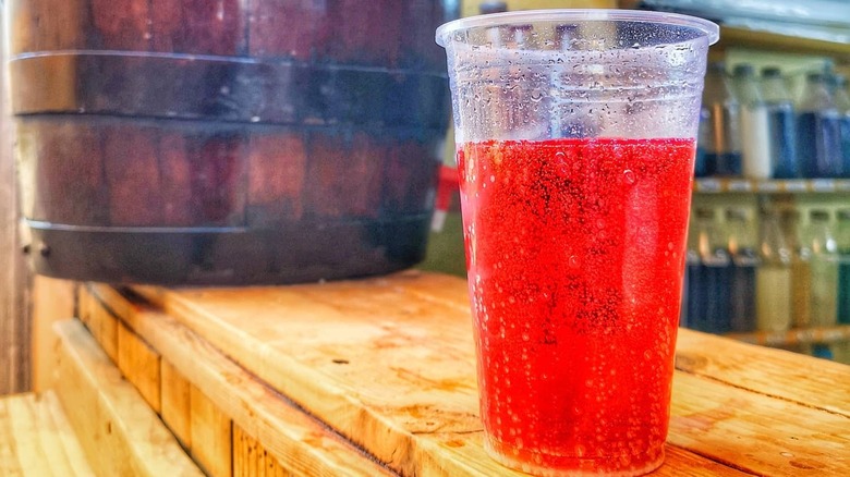 A plastic cup of cebadina on a wooden counter