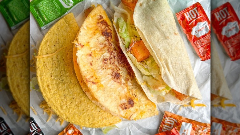 3 taco bell tacos with hot sauce packets