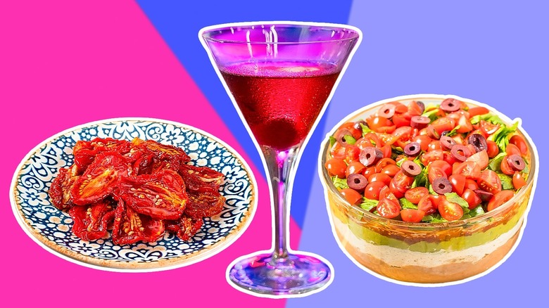 A plate of sun-dried tomatoes, a brightly colored cocktail, and a bowl of seven-layer dip