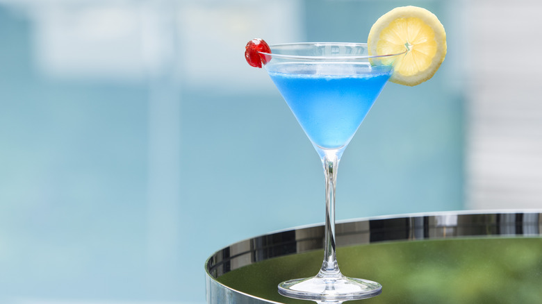 A blue cocktail in a martini glass