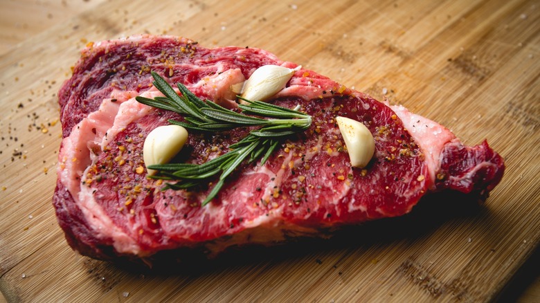 Raw steak with garlic and rosemary