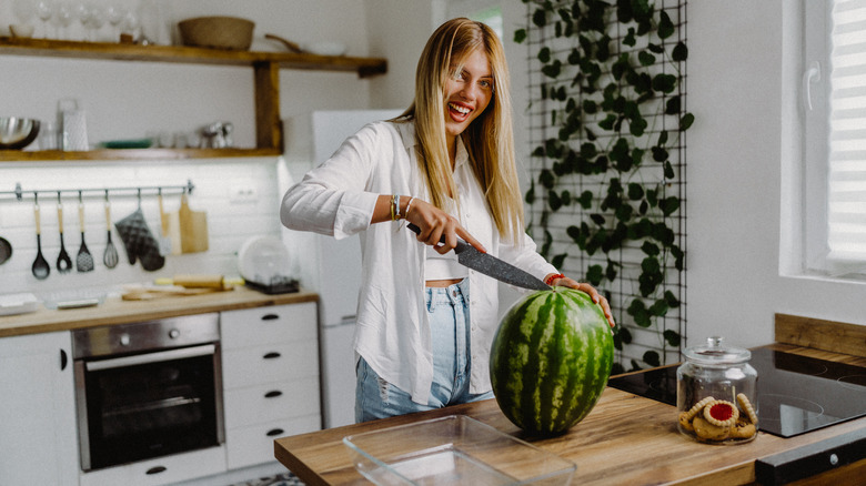 woman cutting watermelon in kitchen