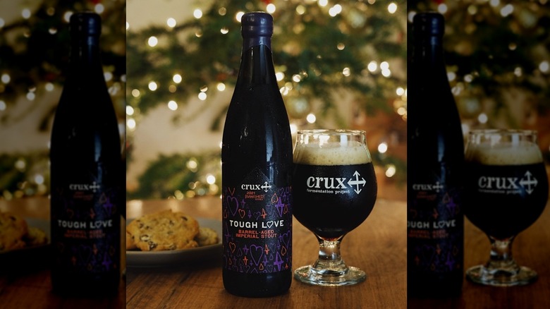 A bottle and glass of Crux Fermentation Tough Love Barrel-Aged Imperial Stout