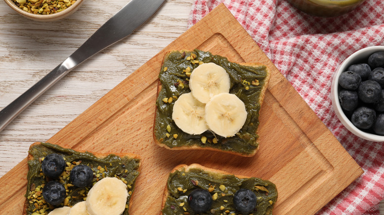 A sandwich with pistachio butter, bananas, and blueberries
