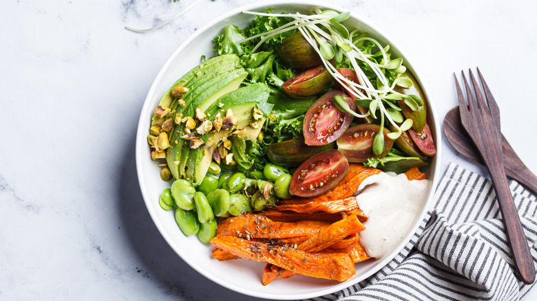 A bowl of vegetables with tahini and pistachio dressing