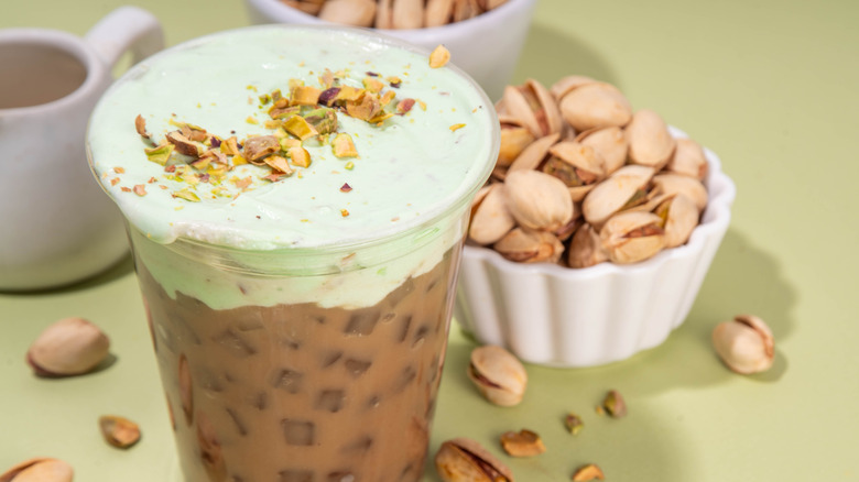 A latte with pistachio cream and chopped pistachios on top