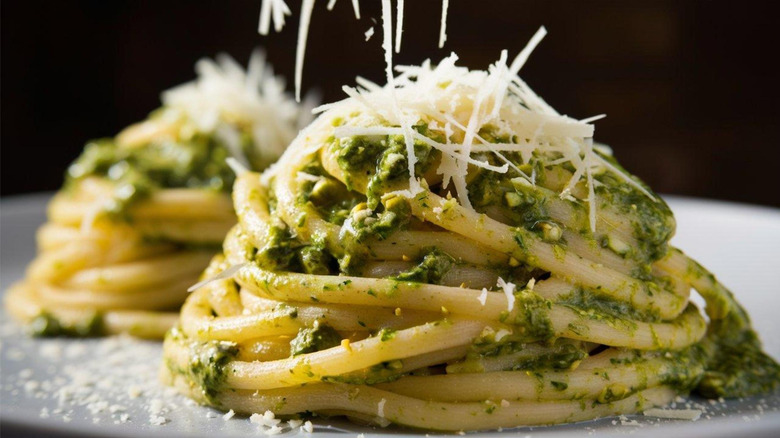 Pasta coated in pistachio pesto with grated cheese on top