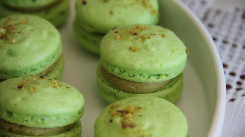 Plate of green pistachio macarons on lace doily