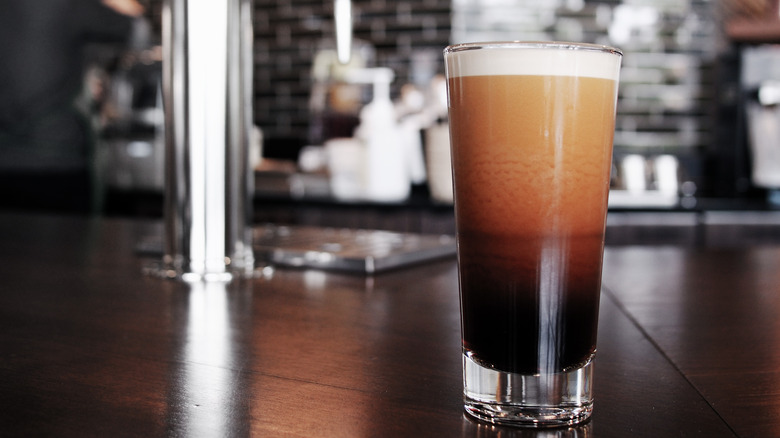 A glass of nitro cold brew coffee on a bar