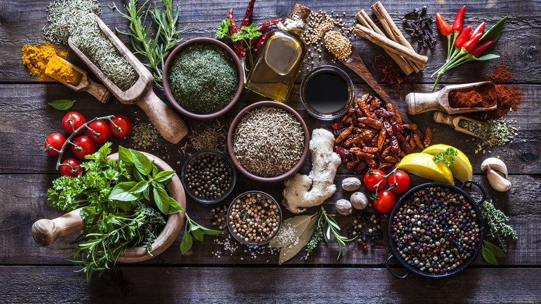 Assorted fresh and dried herbs and spices on a wooden surface
