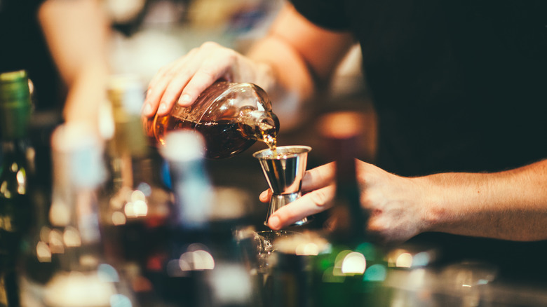 Pouring out liquor in a measuring jigger