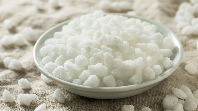 Pearl sugar in a shallow bowl on a tan napkin