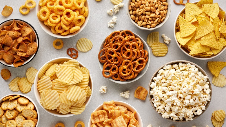 Multiple bowls filled with assorted crunchy and salty snack foods